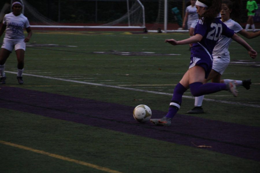 TEAMWORK Junior defender Shea Bell aims a powerful pass down the field to escape North Creek midfielders.
