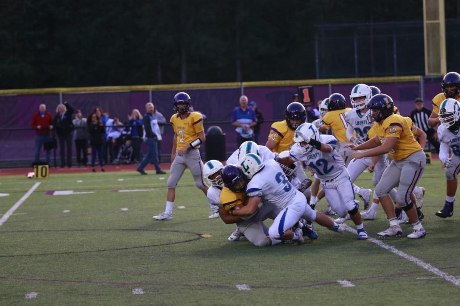 CAREFUL OF CONCUSSIONS! Issaquah’s running back is tackled to the ground by three Liberty defenders in a low-scoring 9-3 loss for Issaquah. Research shows that the repeated blows to one’s head may lead to them developing harmful brain diseases later in their life.