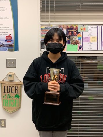 Freshman Justine Wang stands with her Pi Day trophy.